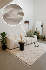 Modern living room with a white sofa, rug, and decorative elements.